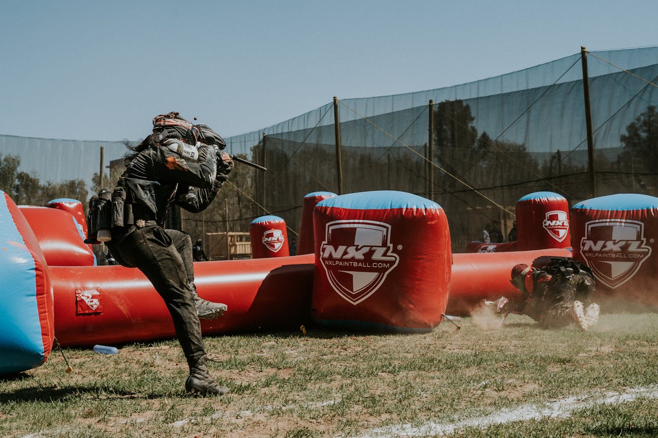 Dynamic scene of players engaged in an intense outdoor paintball match.